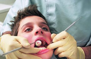 A young man being examined by a dentist